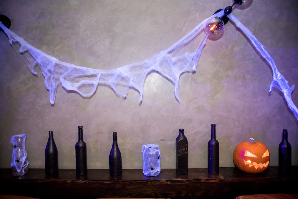 Halloween Decorations: Paint sprayed bottles with jack-o’-lantern and spider web jars and wall feature