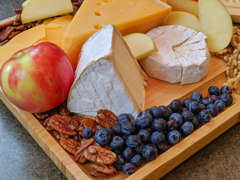 Cheese board with berries, nuts, and fruits
