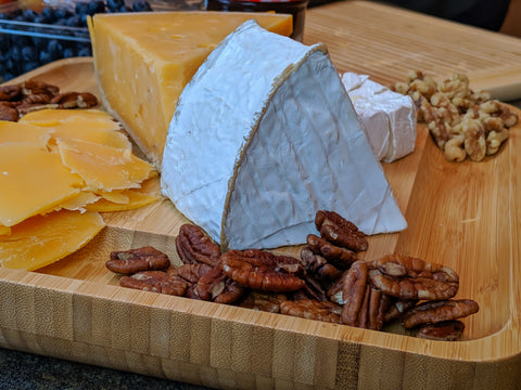 Nuts and cheeses on bamboo cheese board from Vistal