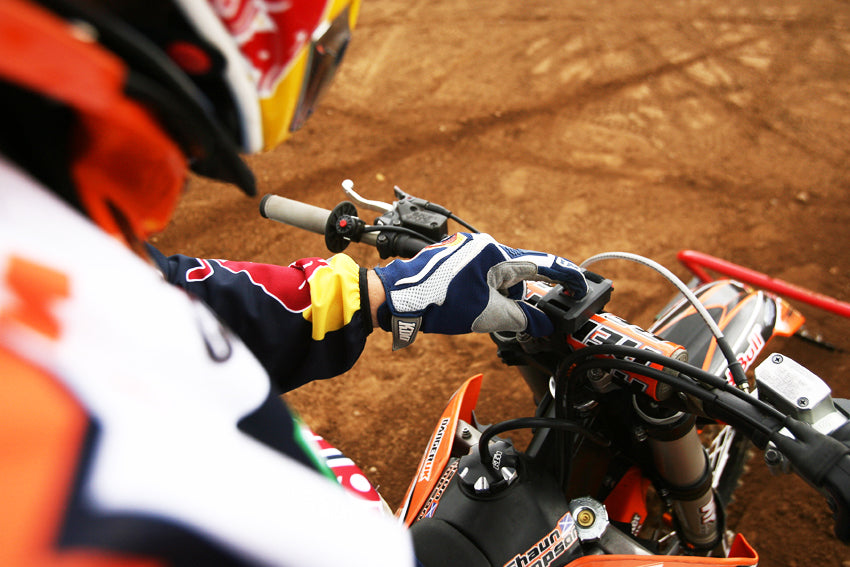 Holeshot Gate remote start. Over the shoulder pic of MX racer pushing the button mounted on his handlebars