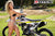 September's Risk Racing Moto Model Denna Lynn posing in various bikinis & Risk Racing Jerseys next to a dirt bike that's sitting on a Risk Racing ATS stand - Pose #11
