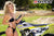 September's Risk Racing Moto Model Denna Lynn posing in various bikinis & Risk Racing Jerseys next to a dirt bike that's sitting on a Risk Racing ATS stand - Pose #18
