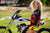 September's Risk Racing Moto Model Denna Lynn posing in various bikinis & Risk Racing Jerseys next to a dirt bike that's sitting on a Risk Racing ATS stand - Pose #21