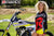 September's Risk Racing Moto Model Denna Lynn posing in various bikinis & Risk Racing Jerseys next to a dirt bike that's sitting on a Risk Racing ATS stand - Pose #8