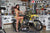 August's Risk Racing Moto Model Samantha Heady posing in various bikinis & Risk Racing Jerseys next to a dirt bike that's sitting on a Risk Racing ATS stand - Pose #8