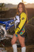 December's Risk Racing Moto Model Kelly Perez posing in various bikinis and Risk Racing Jerseys next to a dirt bike that's sitting on a Risk Racing ATS stand - Pose #22