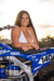 December's Risk Racing Moto Model Kelly Perez posing in various bikinis and Risk Racing Jerseys next to a dirt bike that's sitting on a Risk Racing ATS stand - Pose #31