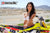Risk Racing's March Moto Model Amber Juliana wearing a white bikini standing behind a motocross bike resting a hand on the seat - close up shot - white fenced off MX track in background