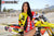 Risk Racing's March Moto Model Amber Juliana wearing a Yellow and Red VENTilate V2 Jersey standing behind a motocross bike - close up shot