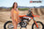 October's Risk Racing Moto Model Dani Hamilton posing in various bikinis and Risk Racing Jerseys next to a dirt bike that's sitting on a Risk Racing ATS stand - Pose #17