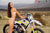October's Risk Racing Moto Model Jessica Victorino posing in various bikinis and Risk Racing Jerseys next to a dirt bike that's sitting on a Risk Racing RR1-Ride-On stand - Pose #17