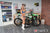 Risk Racing Moto Model Rachel Strait posing in various bikinis and Risk Racing Jerseys next to a dirt bike that's sitting on a Risk Racing ATS stand - Pose #14