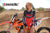 June Moto Model Rochelle Roche wearing a Risk Racing Factory Pit Dry-Fit Shirt tugging it down to cover up her bikini bottoms. She's standing in front of an orange dirt bike. MX track in the background.
