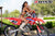July's Risk Racing Moto Model Samantha Heady posing in various bikinis & Risk Racing Jerseys next to Alex Ray's Honda CR250R that's sidding on a Risk Racing ATS stand - Pose #19