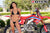 July's Risk Racing Moto Model Samantha Heady posing in various bikinis & Risk Racing Jerseys next to Alex Ray's Honda CR250R that's sidding on a Risk Racing ATS stand - Pose #22