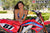 July's Risk Racing Moto Model Samantha Heady posing in various bikinis & Risk Racing Jerseys next to Alex Ray's Honda CR250R that's sidding on a Risk Racing ATS stand - Pose #29