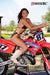July's Risk Racing Moto Model Samantha Heady posing in various bikinis & Risk Racing Jerseys next to Alex Ray's Honda CR250R that's sidding on a Risk Racing ATS stand - Pose #33