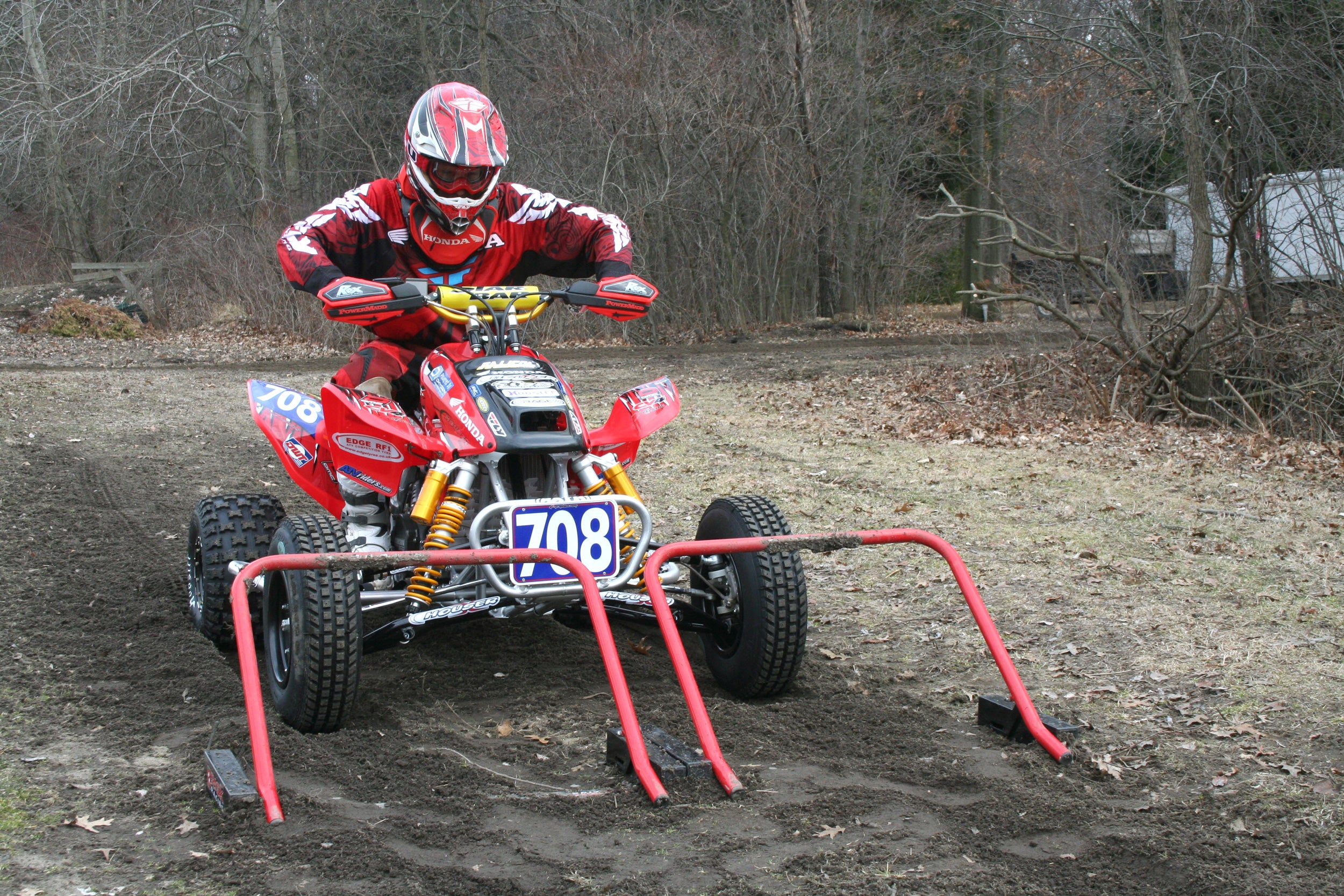 Red quad four wheeler lined up for a race start at two Risk Racing Holeshot race gates