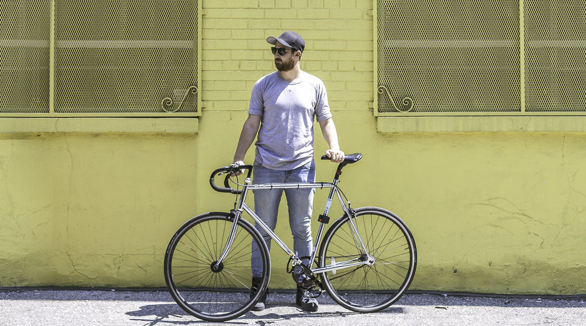 Man wearing cycling glasses standing with bike