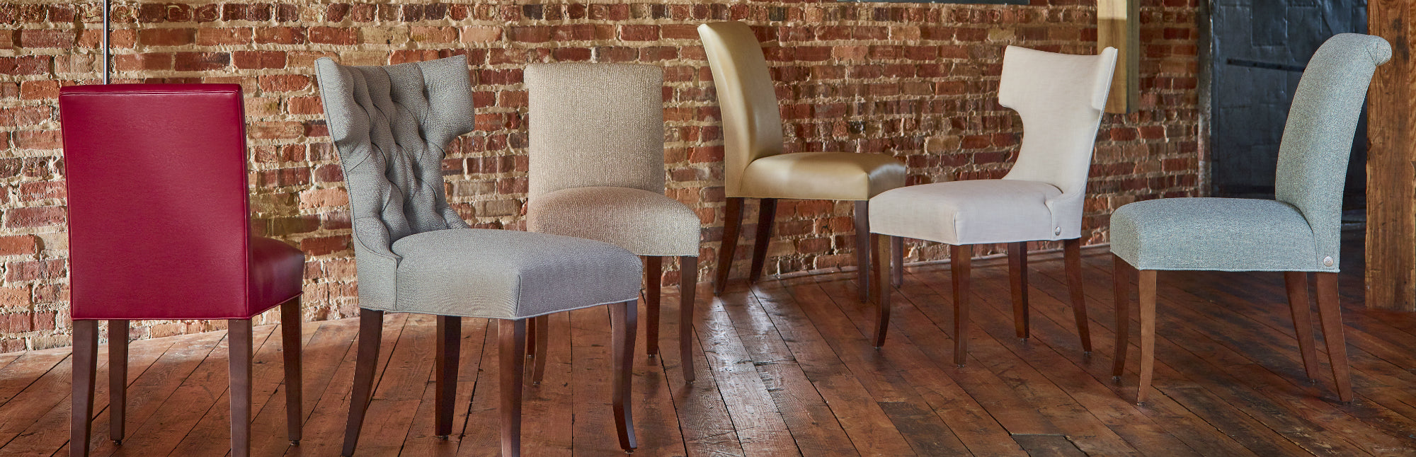 The Cudo Dining Chair collection, lined up against a brick wall.