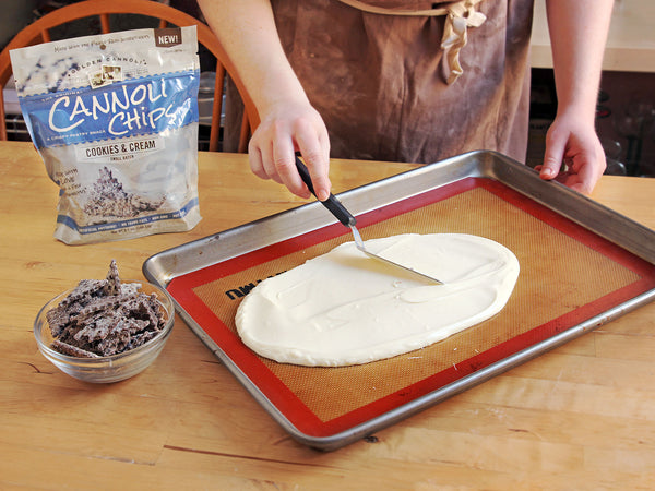 Spreading white chocolate for cookies and cream cannoli chip bark