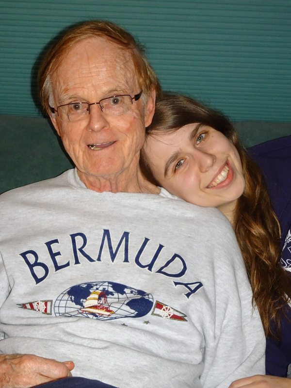 woman smiling with grandfather who has parkinson's