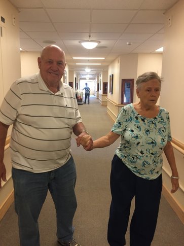 elderly couple walking holding hands