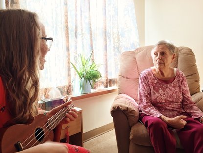 woman playing instrument for woman with dementia