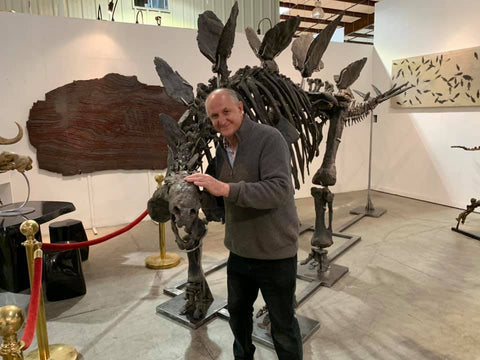Tom Kapitany standing with dinosaur fossil