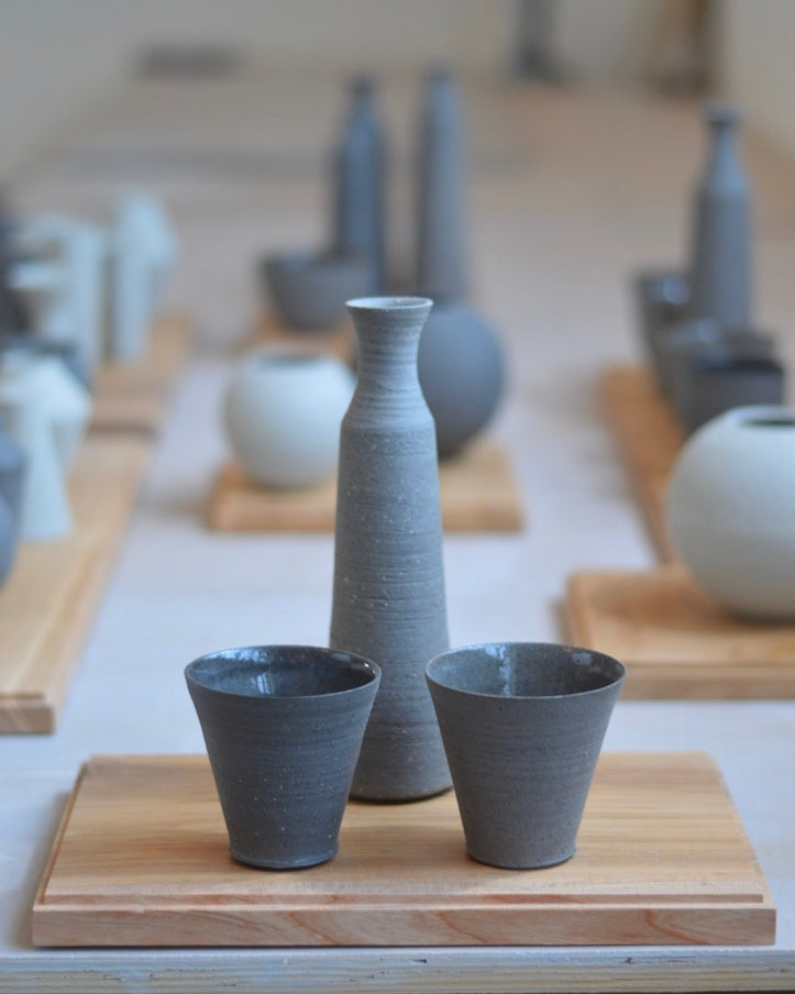 A selection of grey ceramic cups and vases by UK-based potter Jono Smart