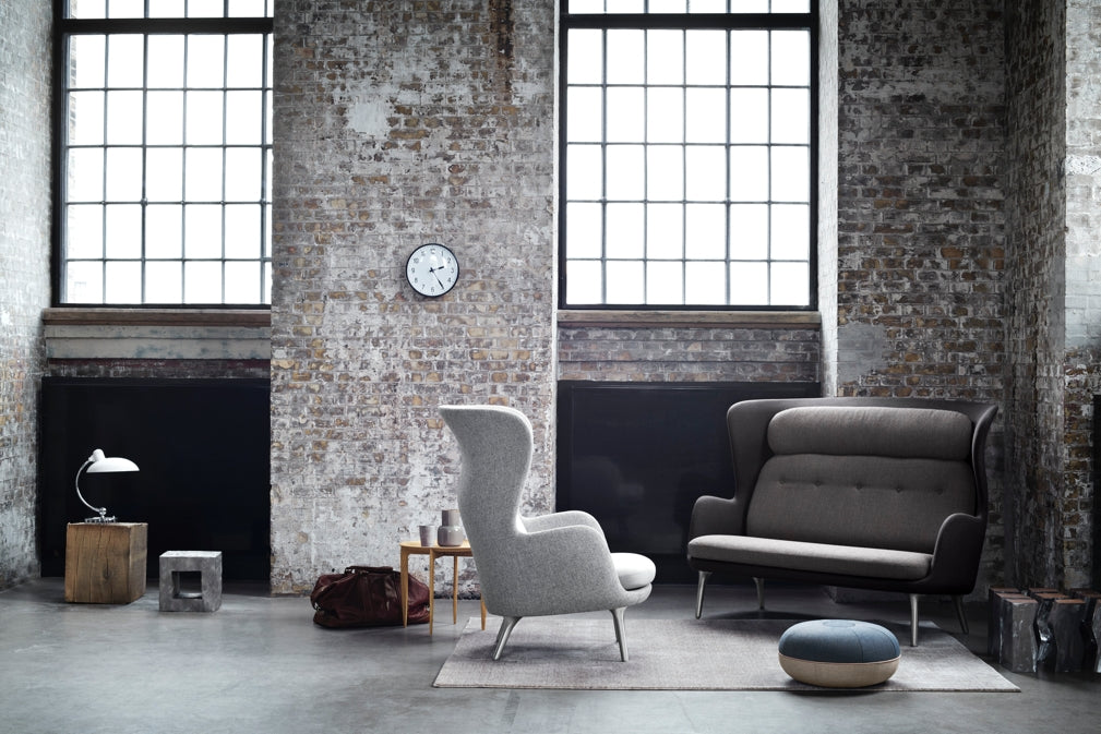 An industrial chic living room features designs by Fritz Hansen including the 7263 Ro Sofa in Dark grey