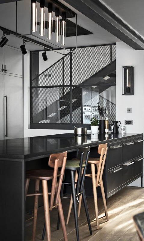 Angled view of an industrial chic kitchen featuring CAGED lighting by Buster + Punch