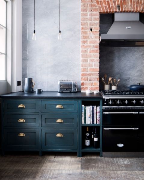 Industrial style Kitchen featuring range cooker against exposed brick wall. Havwoods weathered rustic surface flooring 
