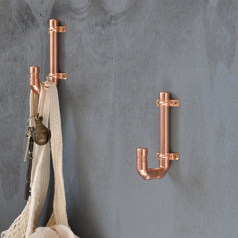 a pair of copper pipe coat hooks in industrial style