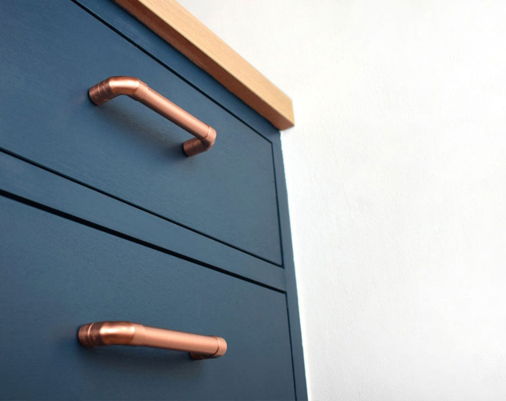 Proper Copper Design blue kitchen cabinet fearturing copper handles