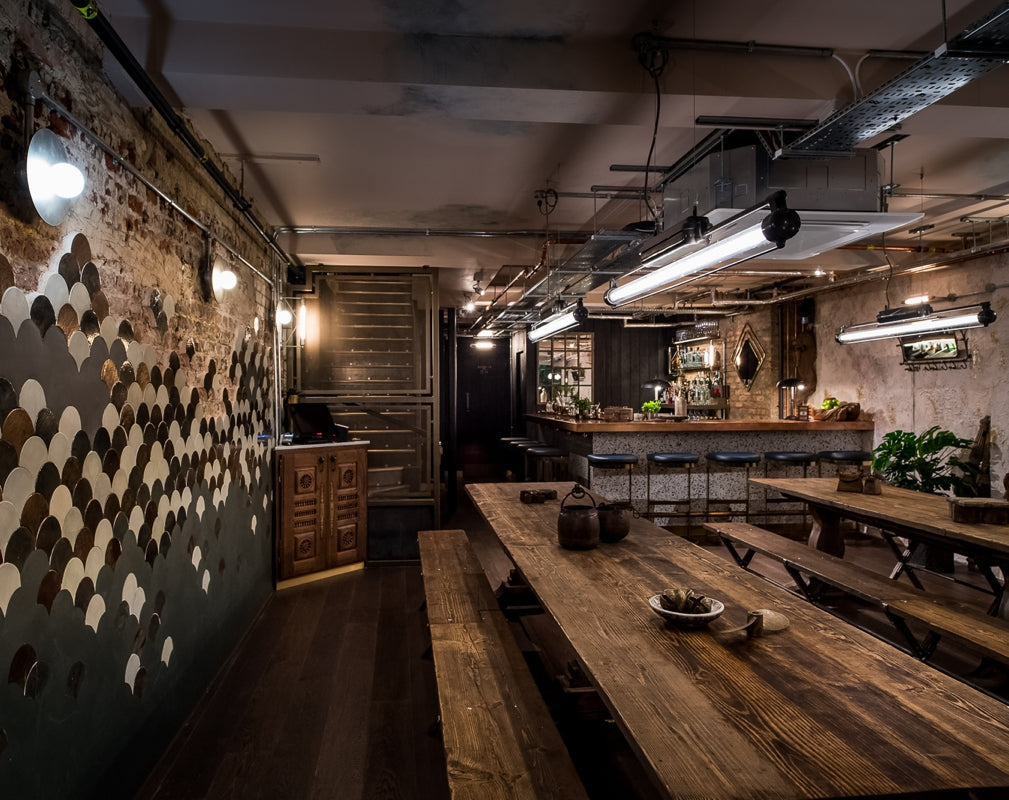 Rustic communal tables feature at Kricket Soho in London designed by Run For The Hills