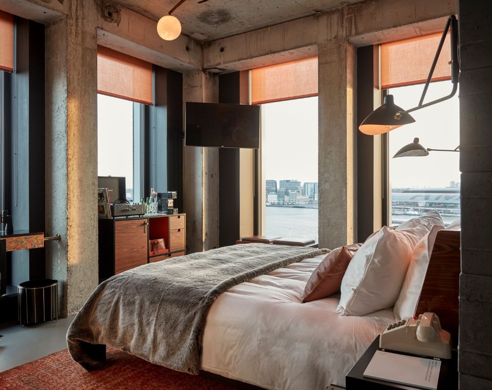 Sir Adam Hotel in Amsterdam. Guestroom featuring floor to ceiling windows an stunning views over the city.
