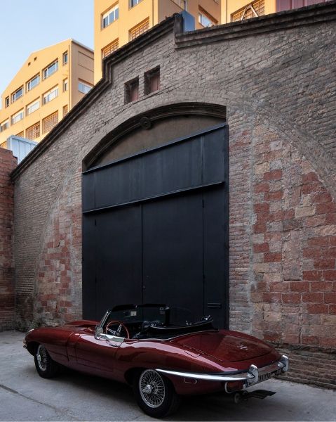The Theatre converyed warehouse by Cadaval Sola-Morales. The red brick exterior has a large metal swing doors to give access to the classic car.