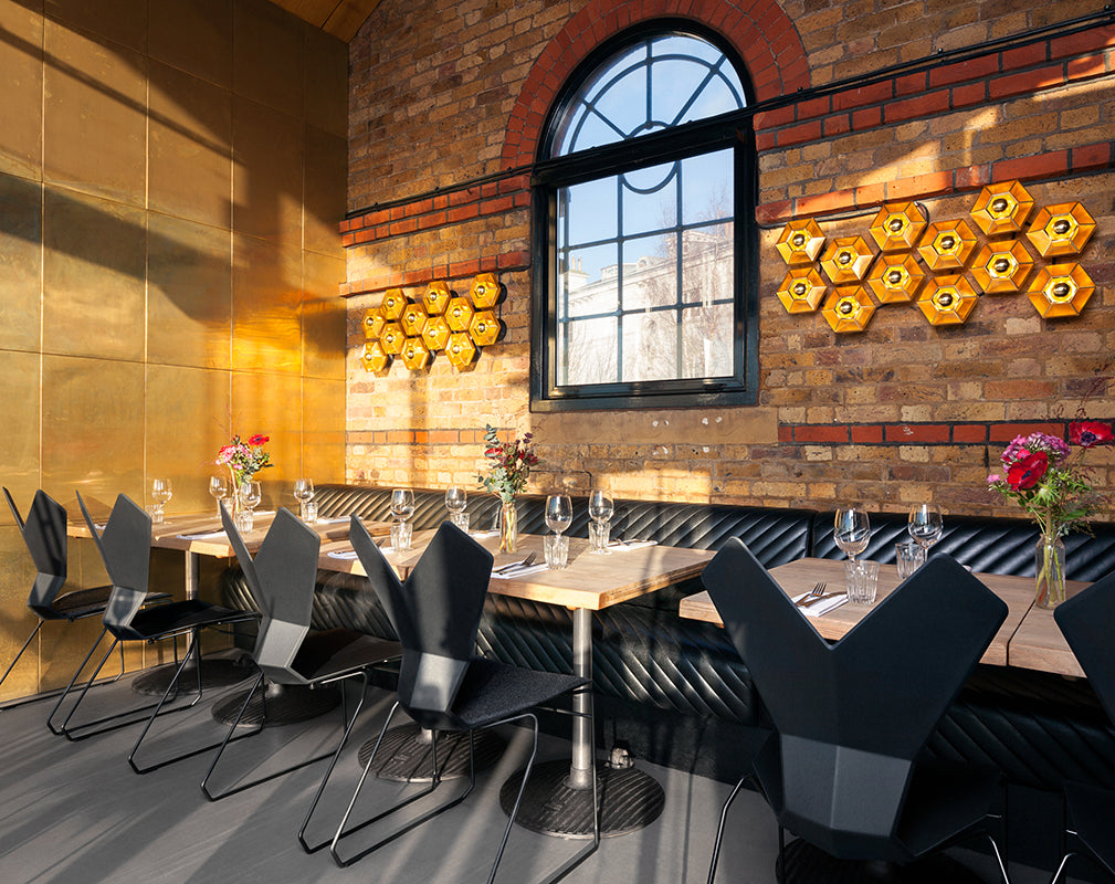 exposed brickwork and brass features in the restaurant interior of the dock kitchen by tom dixon