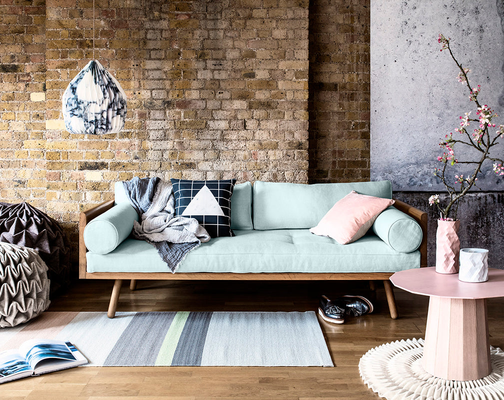 warehouse conversion with exposed brick wall and pastel interior scheme.