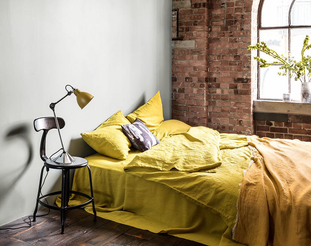 Stylish bedroom in a converted warehouse with exposed brick wall and warehouse window