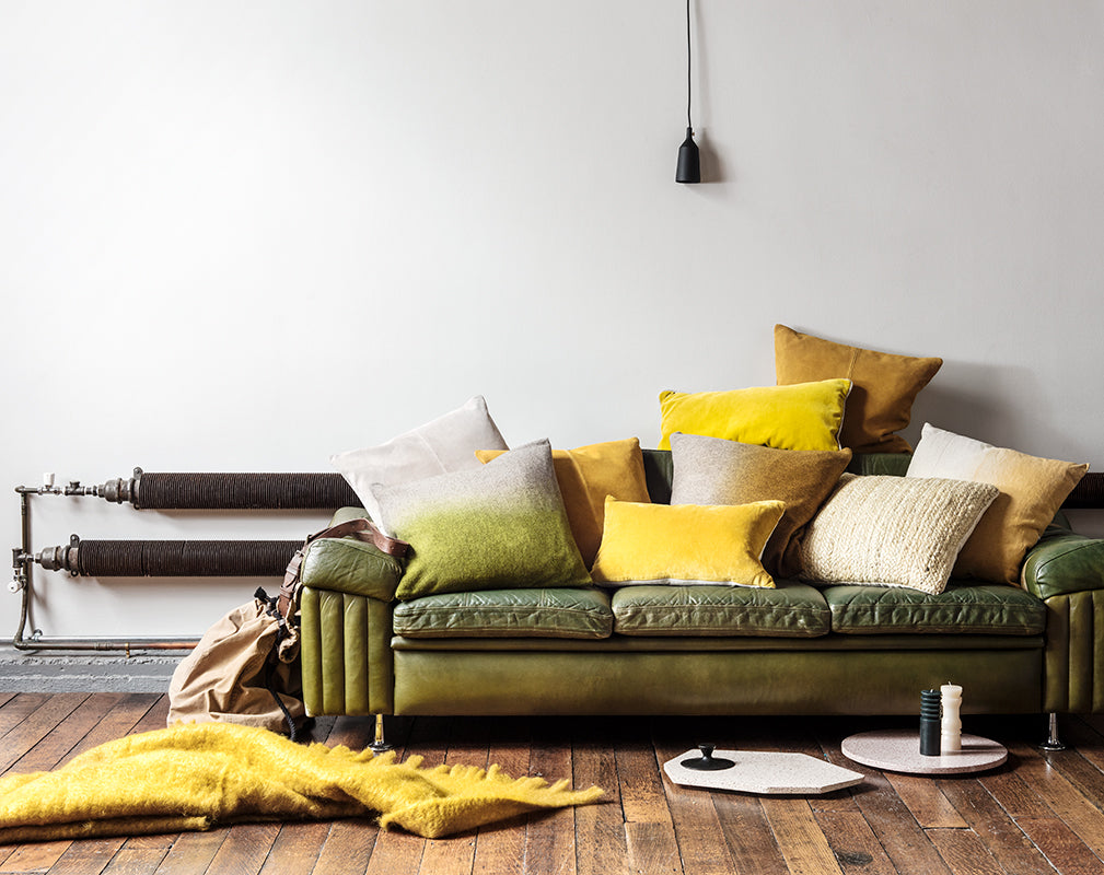 Vintage green sofa with yellow and green cushions and matt black pendant