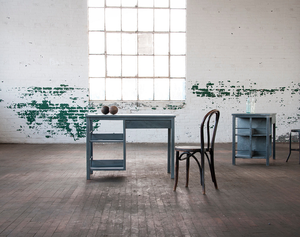 Vintage Bel Geddes minimalist trestle desk against exposed warehouse brick.