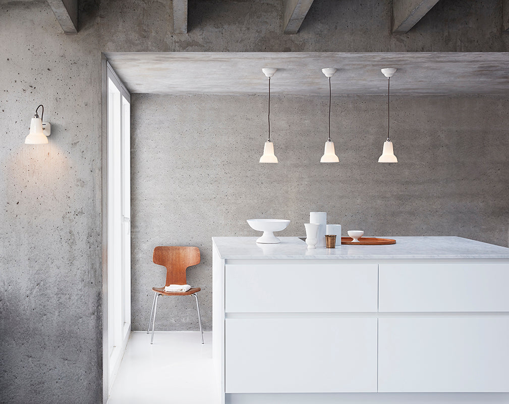 Concrete interior walls and beams with ceramic anglepoise pendants.