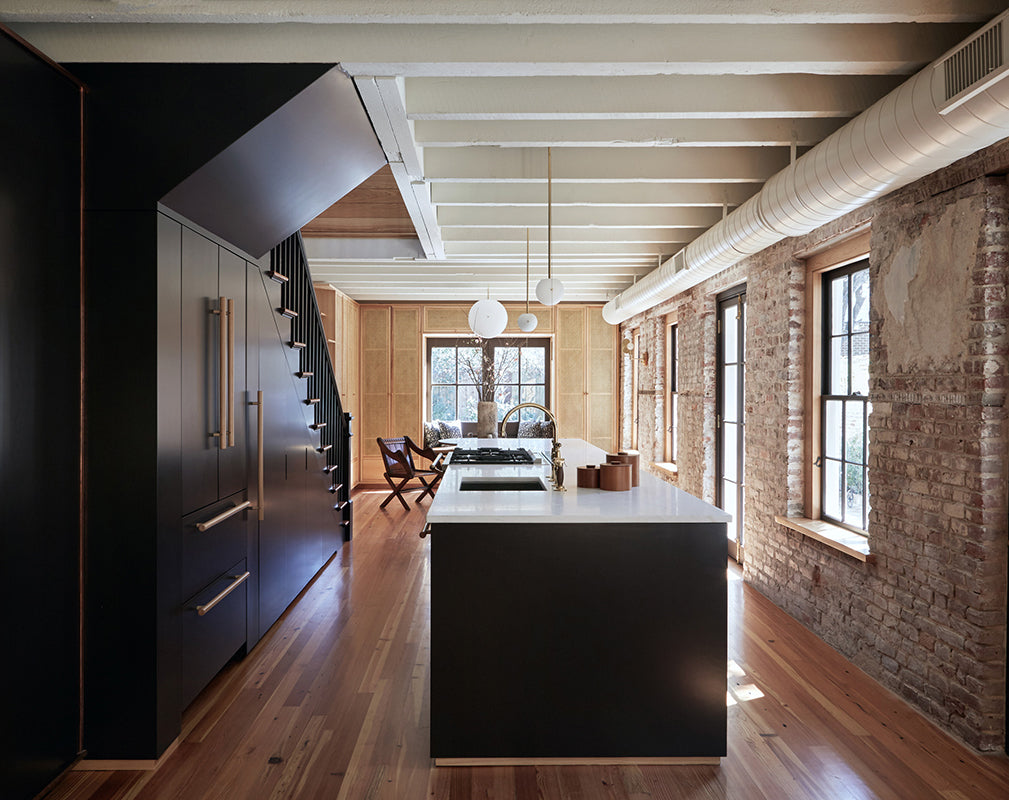 a minimalist kitchen scheme complements original brick and exposed beams