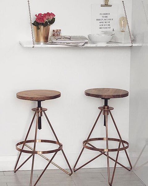a pair of industrial style kitchen bar stools with hairpin legs in copper