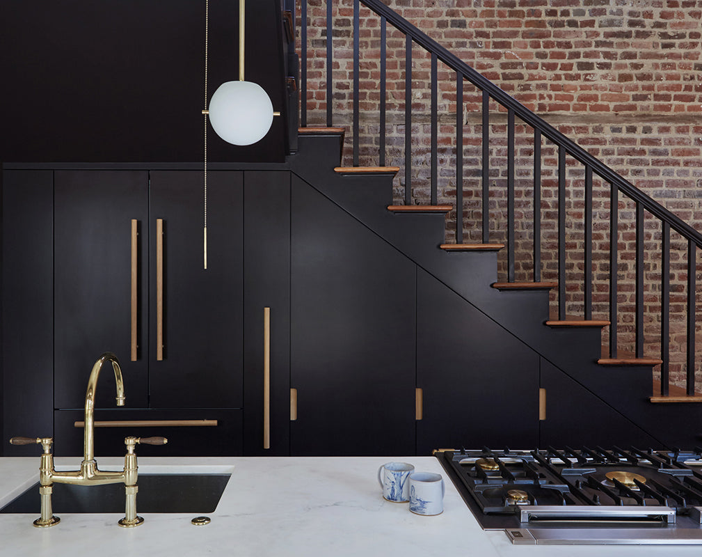 a sleek black staircase serves as a focal point in this converted industrial building