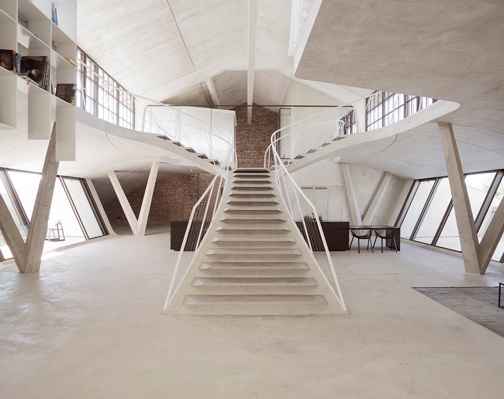 a sculptural staircase features in this converted warehouse loft in salzburg austria