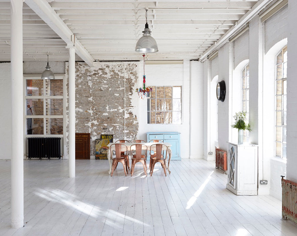 converted warehouse in london with painted white brickwork and vintage industrial furniture.