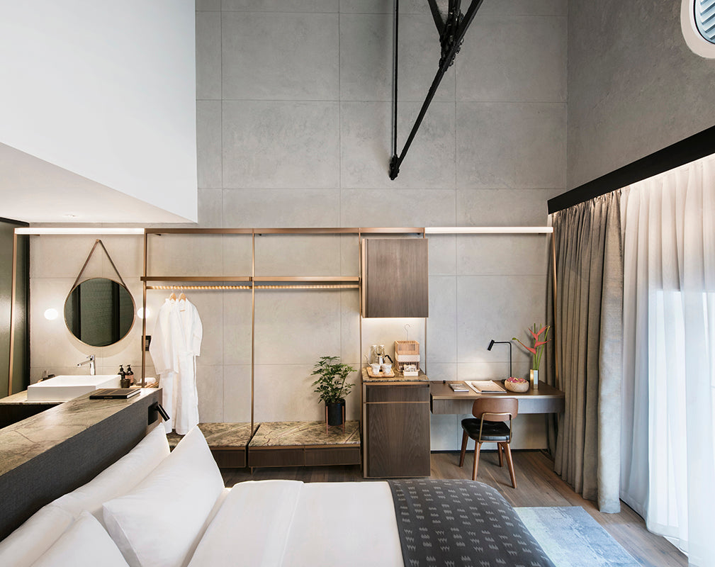 the loft suite of the warehouse hotel singapore features an industrial luxe scheme and river views
